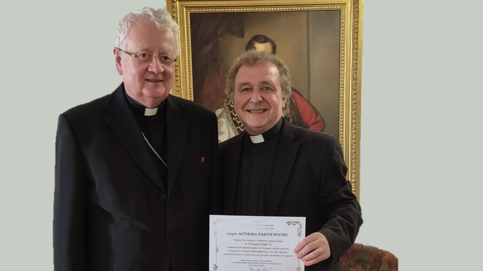Vlastimil Dufka SJ preberá ocenenie liturgickej komisie